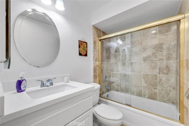 full bathroom featuring bath / shower combo with glass door, vanity, and toilet