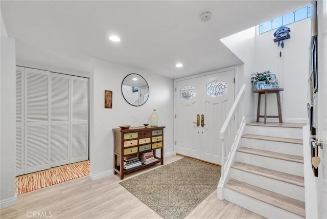 entrance foyer with stairs, baseboards, wood finished floors, and recessed lighting