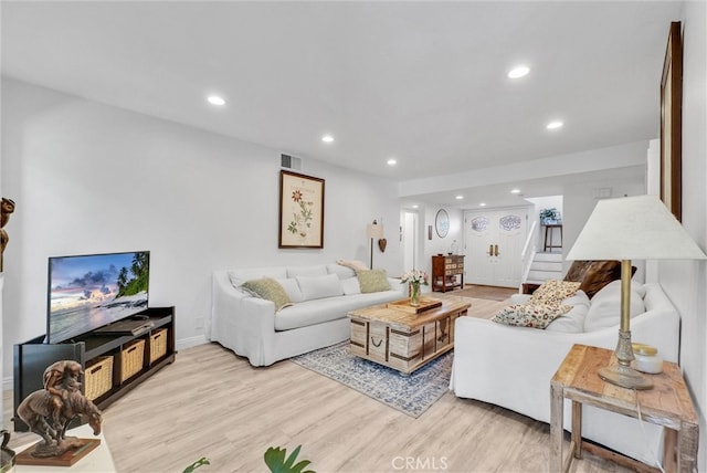 living area with stairway, light wood-type flooring, visible vents, and recessed lighting