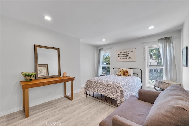 bedroom featuring baseboards, wood finished floors, and recessed lighting