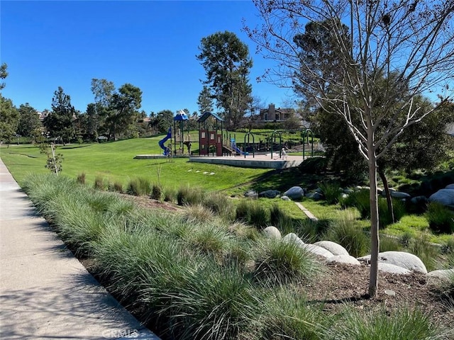 view of community featuring playground community and a yard