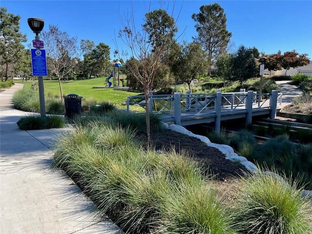 view of property's community featuring a lawn and playground community