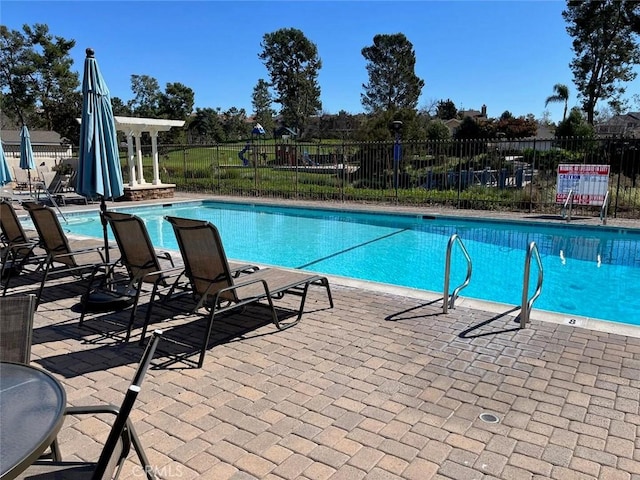 pool with fence and a patio