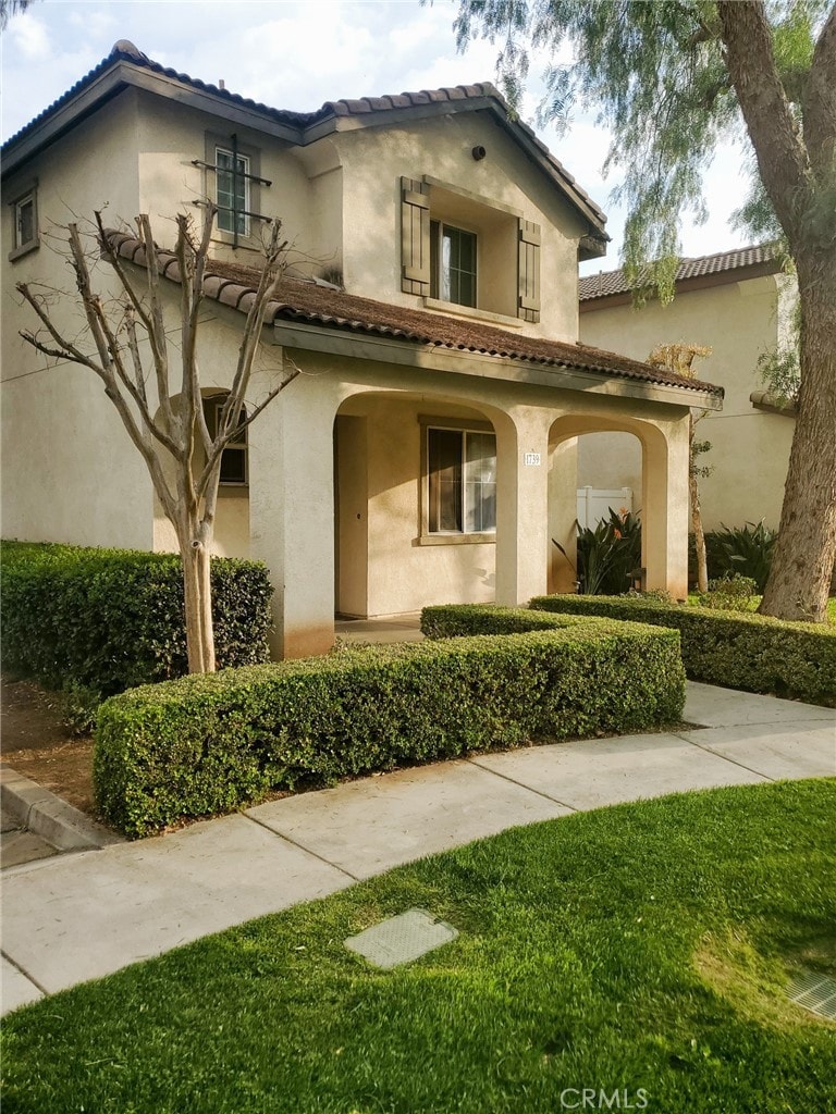 mediterranean / spanish-style home with a tiled roof and stucco siding