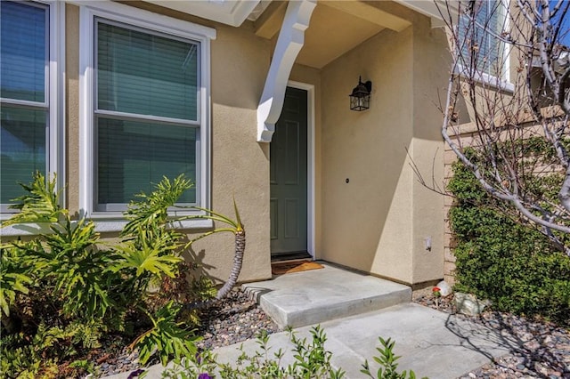 view of exterior entry with stucco siding