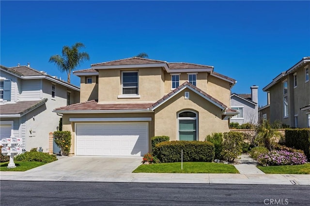 view of front of house with an attached garage, concrete driveway, stucco siding, and a tile roof