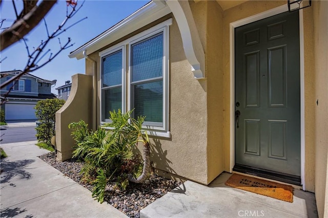 entrance to property featuring stucco siding