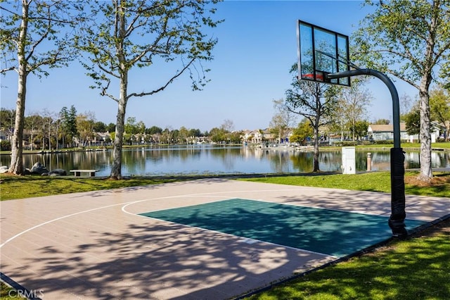 view of sport court featuring community basketball court, a water view, and a lawn