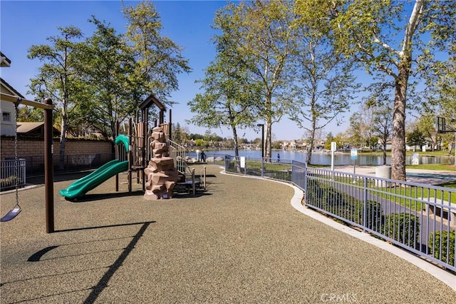 community playground featuring a water view, cooling unit, and fence