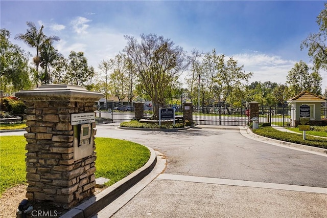 view of street with a gated entry, curbs, and a gate
