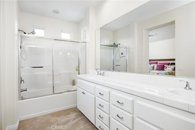 full bathroom featuring combined bath / shower with glass door, ensuite bathroom, a sink, and double vanity