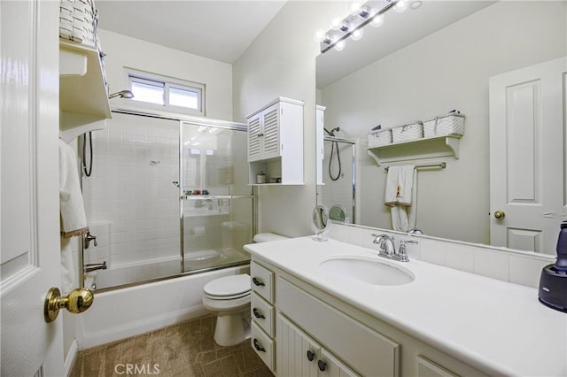full bath featuring toilet, vanity, tile patterned floors, and shower / bath combination with glass door