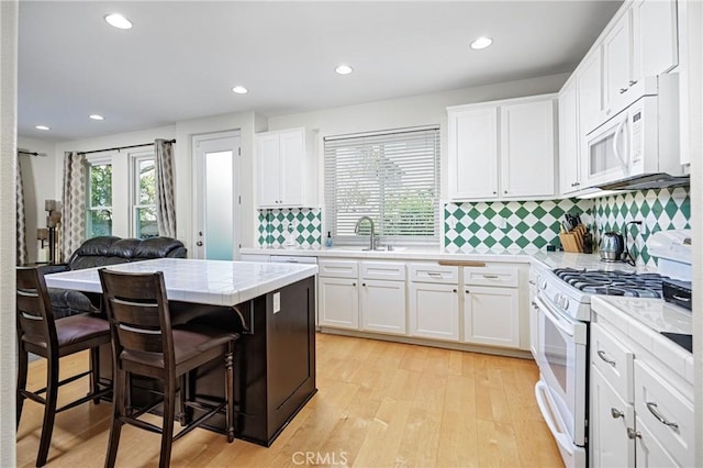 kitchen featuring tile countertops, white cabinets, and white appliances
