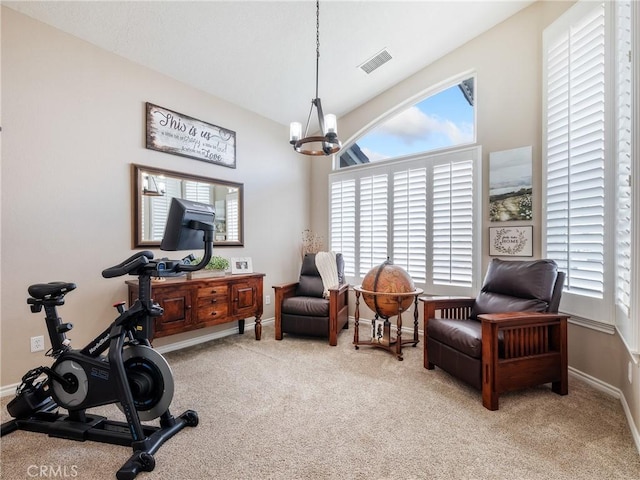 exercise room featuring carpet floors, visible vents, baseboards, and an inviting chandelier