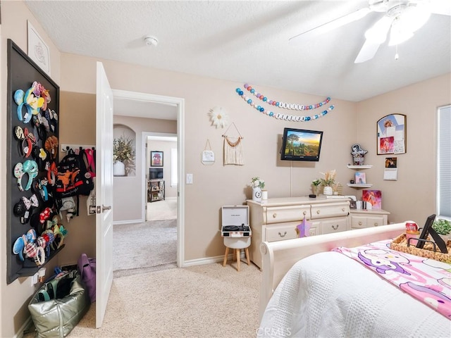 bedroom featuring carpet, a textured ceiling, baseboards, and a ceiling fan