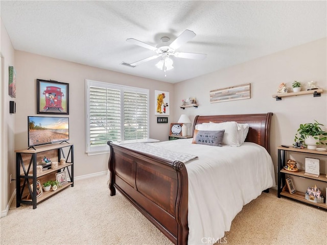 bedroom featuring visible vents, light colored carpet, ceiling fan, a textured ceiling, and baseboards