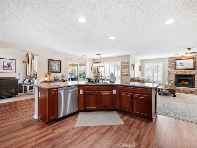 kitchen featuring dark wood-style floors, a fireplace, open floor plan, and dishwasher