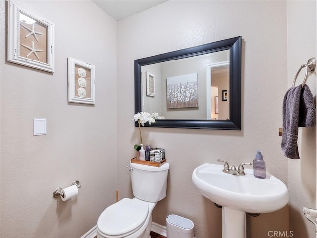 bathroom featuring toilet and baseboards