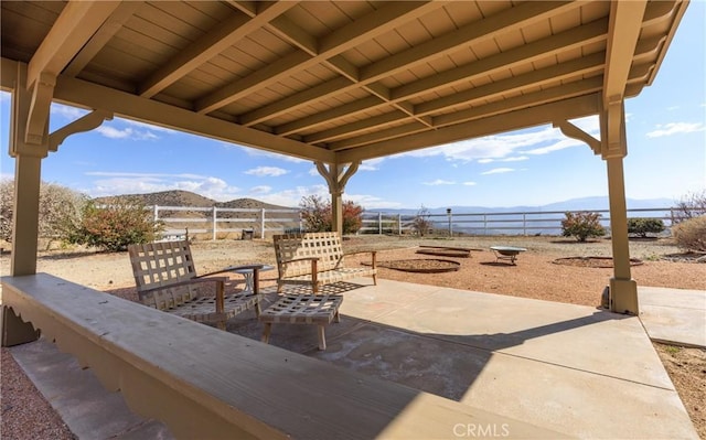 view of patio / terrace featuring fence and a mountain view