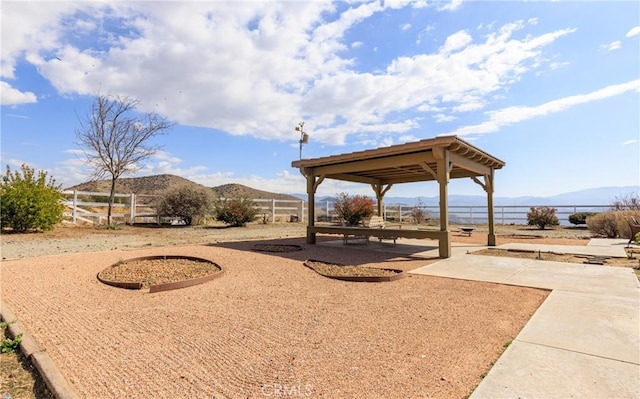 view of yard featuring a mountain view, a patio, a gazebo, and fence