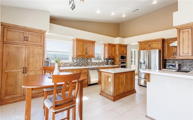 kitchen featuring light countertops, visible vents, backsplash, appliances with stainless steel finishes, and a kitchen island