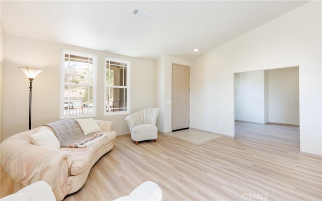 living area featuring light wood-type flooring, visible vents, vaulted ceiling, and recessed lighting