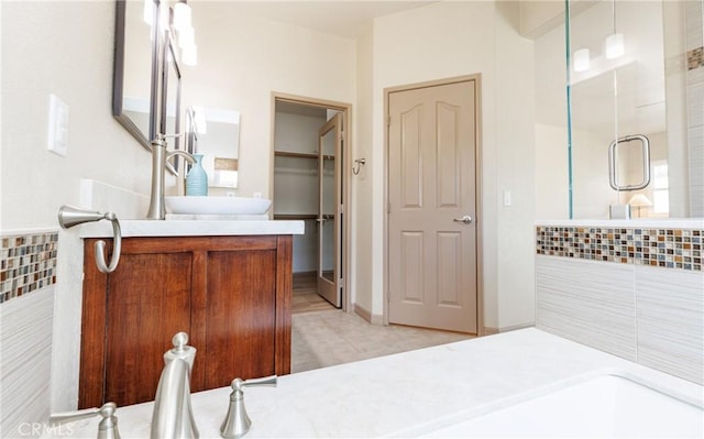 bathroom featuring a closet, a shower stall, and vanity