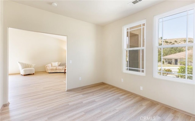 empty room featuring visible vents and light wood-style floors