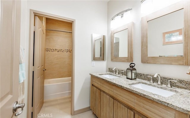 full bath with double vanity, tub / shower combination, a sink, and tile patterned floors