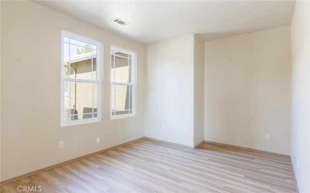 empty room featuring visible vents and light wood-style flooring