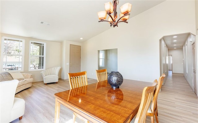 dining space featuring high vaulted ceiling, recessed lighting, a notable chandelier, and light wood-style flooring