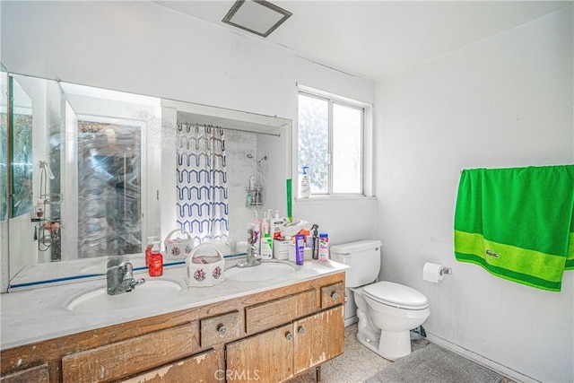 full bath featuring double vanity, a sink, and toilet