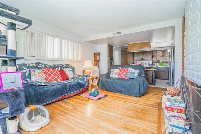 interior space with a textured ceiling, wood finished floors, and visible vents