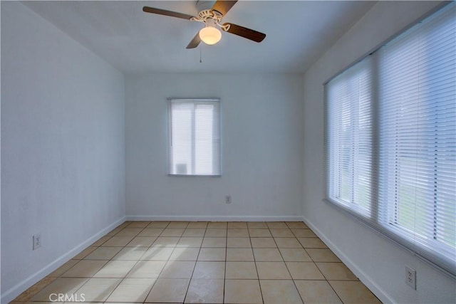 empty room with ceiling fan, baseboards, and light tile patterned floors