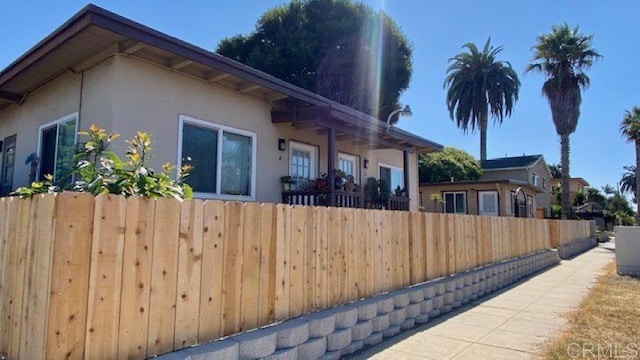 view of property exterior featuring fence and stucco siding