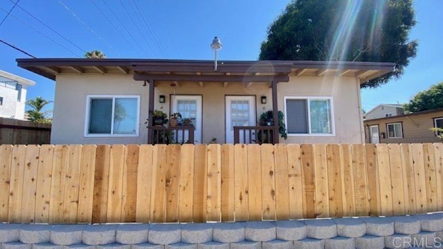 view of front of home featuring a fenced front yard and stucco siding