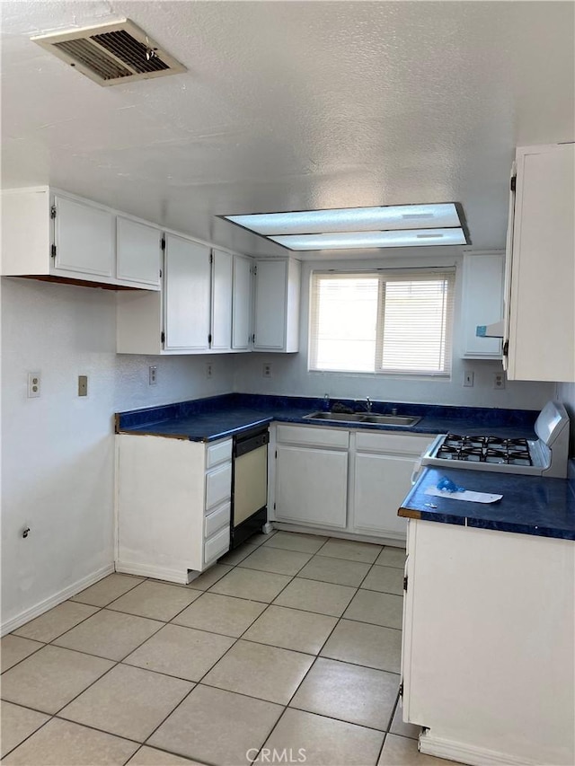 kitchen with light tile patterned flooring, a sink, visible vents, white cabinetry, and dishwasher