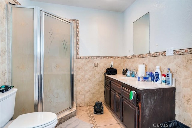 bathroom featuring tile patterned flooring, tile walls, toilet, and a stall shower