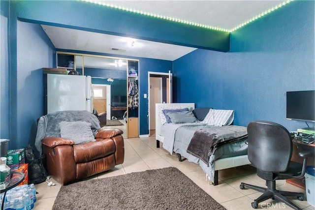 tiled bedroom with freestanding refrigerator