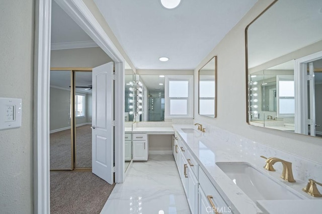 bathroom with a shower, marble finish floor, a sink, and double vanity