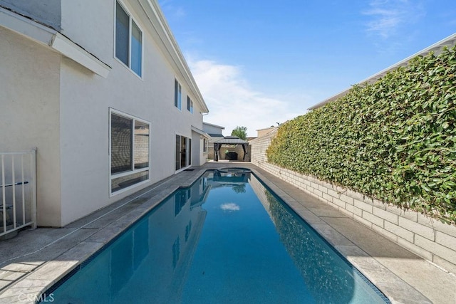 view of swimming pool featuring a fenced in pool, a patio area, fence, and a gazebo