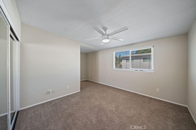 unfurnished bedroom featuring carpet floors, a closet, a textured ceiling, and baseboards