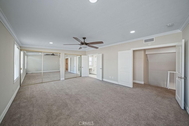 unfurnished bedroom with ornamental molding, carpet, recessed lighting, and multiple closets