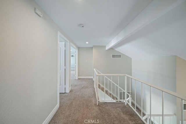 hall featuring carpet, visible vents, lofted ceiling with beams, an upstairs landing, and baseboards