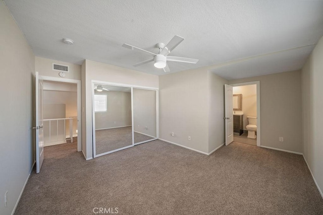 unfurnished bedroom featuring a closet, visible vents, a textured ceiling, and carpet flooring