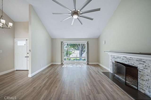 unfurnished living room featuring a stone fireplace, wood finished floors, and baseboards