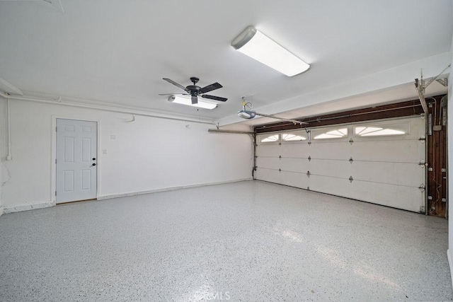 garage with ceiling fan, baseboards, and a garage door opener