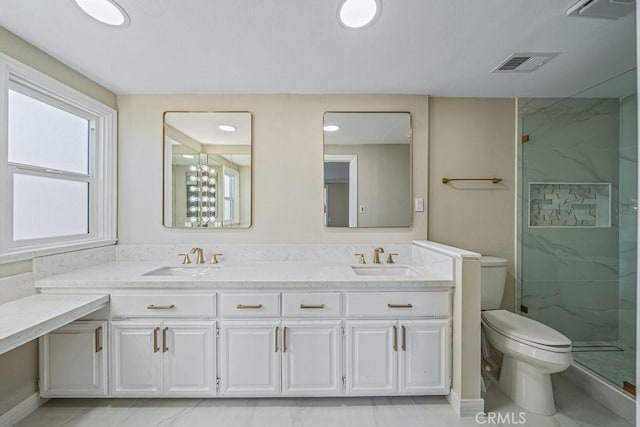 full bath featuring toilet, a marble finish shower, a sink, and visible vents