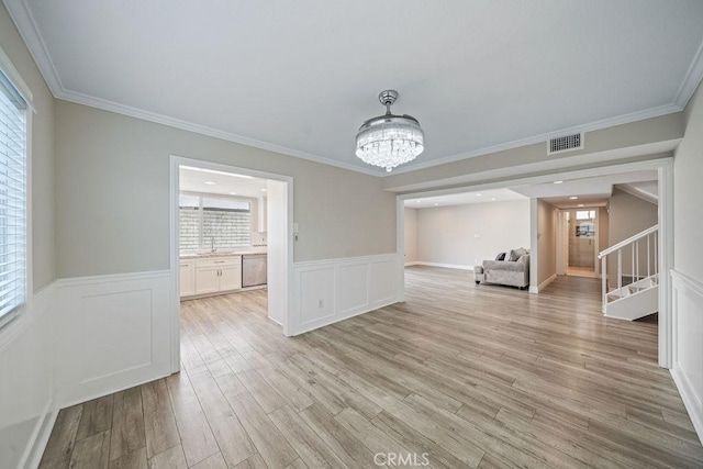 interior space featuring a notable chandelier, visible vents, light wood-style flooring, stairway, and a healthy amount of sunlight