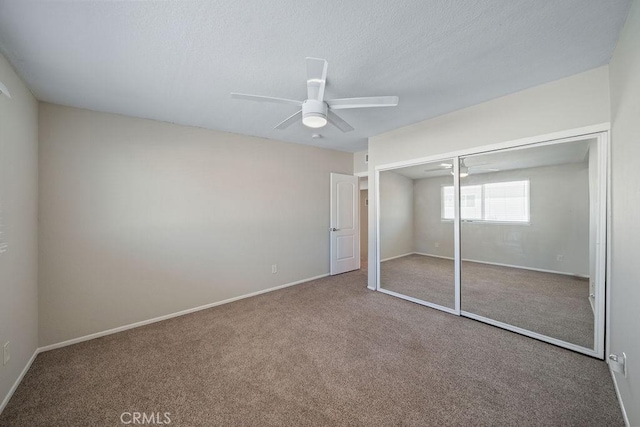 unfurnished bedroom featuring baseboards, a ceiling fan, carpet, a textured ceiling, and a closet